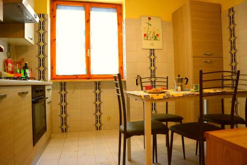 une cuisine avec une table et des chaises et une fenêtre dans l'établissement Casa Vacanze Vecchia Torre, à Gallipoli