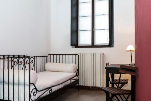 a bedroom with a bed and a desk and a window at Cascina Scanna in Cisliano