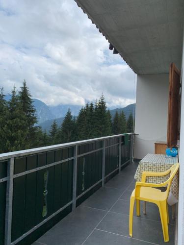 a balcony with a table and a yellow chair on it at Appartamento Rustico in Candide