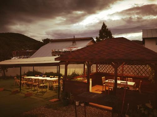 eine Terrasse mit Tischen und Stühlen und einem Pavillon in der Unterkunft Natalia Guesthouse in Sărata-Monteoru