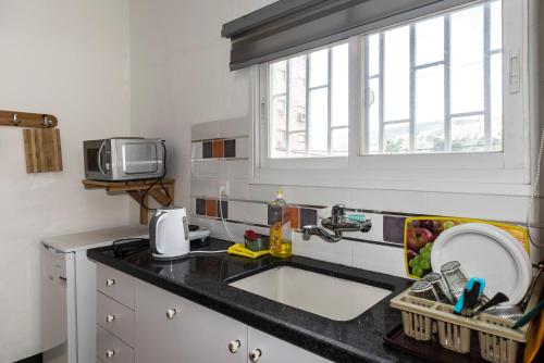 um balcão de cozinha com um lavatório e uma janela em David Hostel em Tiberias
