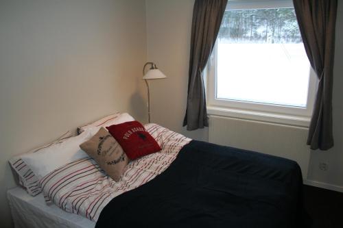 a bedroom with a bed with two pillows on it at Kvåstunet in Lyngdal
