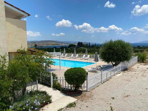 a swimming pool with chairs and a fence at Leonidas Resort in Ermioni