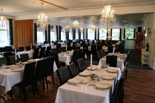 a dining room with tables and chairs and chandeliers at Kvåstunet in Lyngdal