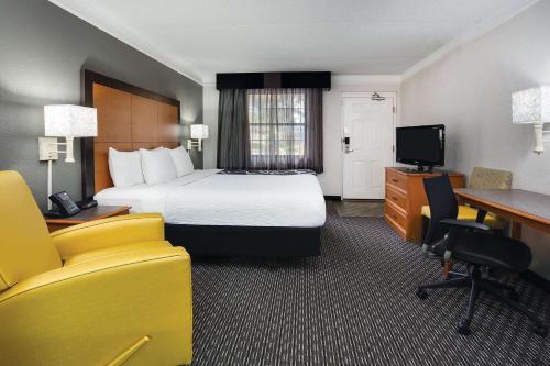 a hotel room with a bed and a desk at Days Inn by Wyndham Gainesville Florida in Gainesville