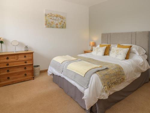 a bedroom with a large bed and a wooden dresser at Crabtree Cottage in Scarborough