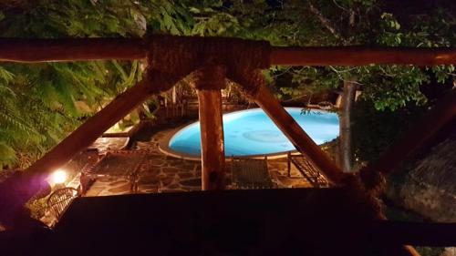 Boutique Hotel Nyumbani Tembo في واتامو: مسبح في ساحة بالليل