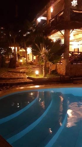 a night view of a swimming pool in a resort at Boutique Hotel Nyumbani Tembo in Watamu