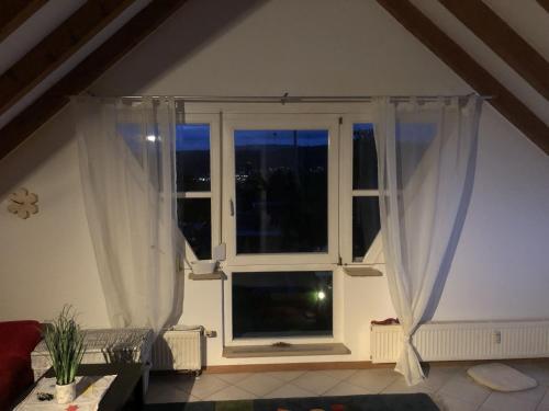 uma janela com cortinas brancas num quarto em Ferienwohnung Tetto Piccolo em Bad Säckingen