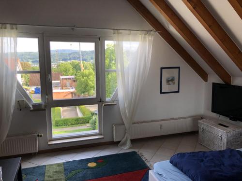 um quarto com uma cama e uma grande janela em Ferienwohnung Tetto Piccolo em Bad Säckingen