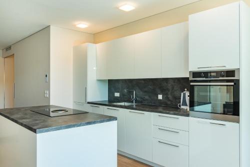 a kitchen with white cabinets and a counter top at Park Hill Residences in Rabac