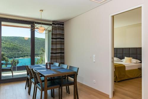a dining room with a table and chairs and a bedroom at Park Hill Residences in Rabac