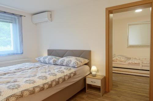 - une chambre avec un lit et un miroir dans l'établissement Apartments Laura FARM STAY, à Podčetrtek