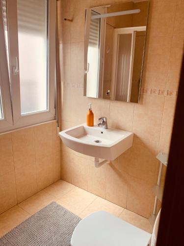a bathroom with a sink and a mirror and a toilet at Estudios Blanmart in Santander