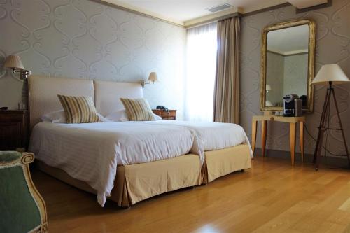 ein Schlafzimmer mit einem großen Bett und einem großen Spiegel in der Unterkunft Hotel Restaurant Chartron in Saint-Donat-sur-lʼHerbasse