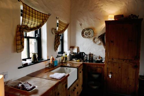 cocina con fregadero y ventana en The Spinner's Cottage, en Donegal
