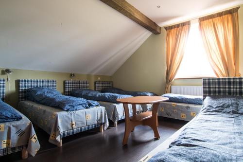 a room with four beds and a table and a window at Virinta in Toliejai