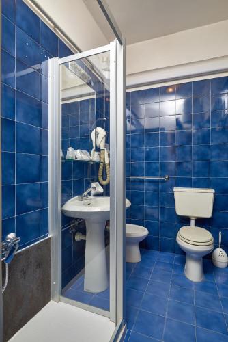 a blue tiled bathroom with a toilet and a sink at Hotel Garibaldi in Finale Ligure