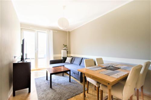 a living room with a table and a couch at Apartament Batory in Gdynia