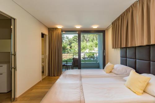 a bedroom with a large bed and a balcony at Park Hill Residences in Rabac