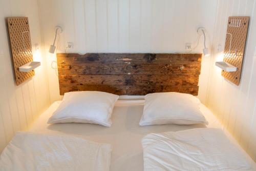 um quarto com uma cama com duas almofadas brancas em Samsted em Middelfart