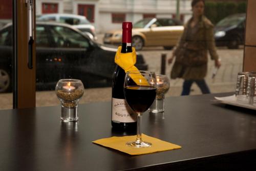 una botella de vino sentada en una mesa con dos copas en Pension Levi, en Berlín