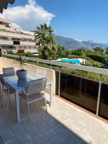 un patio avec une table et des chaises sur un balcon dans l'établissement Superbe 2P vue mer, ensoleillé, piscine, à Roquebrune-Cap-Martin
