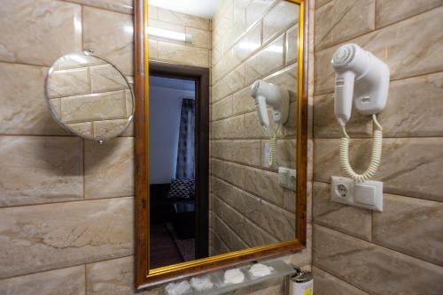 a bathroom with a mirror and a hair dryer at Rhombus Hotel in Luts'k
