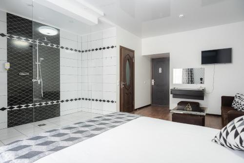 a bedroom with a large bed and a shower at Rhombus Hotel in Luts'k