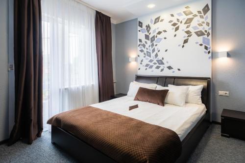 a bedroom with a bed and a large window at Rhombus Hotel in Luts'k