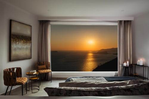 a bedroom with a large window with a view of the ocean at Athermi Suites - Adults Only in Megalokhori