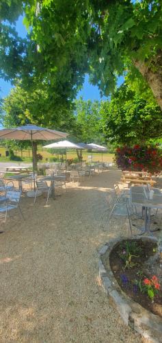 un groupe de tables et de chaises avec parasols dans l'établissement Hôtel Restaurant Auberge des crêtes du Verdon, à La Palud-sur-Verdon