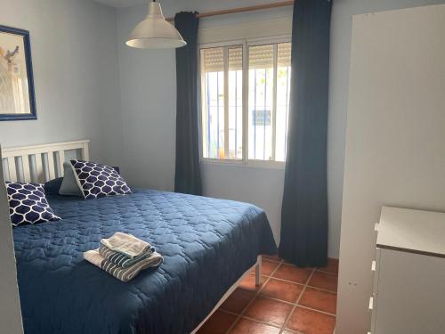een slaapkamer met een bed met blauwe lakens en een raam bij Finca Casa Mici in Alhaurín el Grande