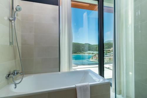 a bathroom with a bath tub and a window at Park Hill Residences in Rabac