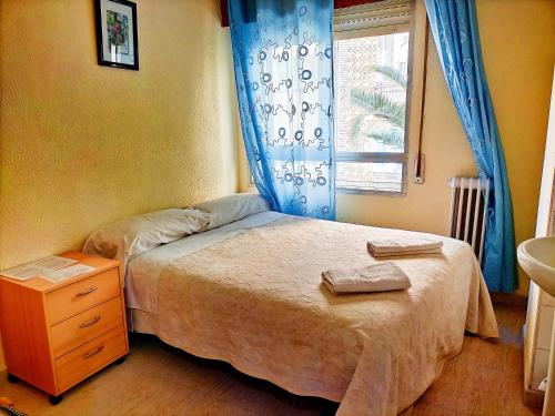 Habitación pequeña con cama y ventana en AB Pension Granada en Granada