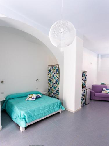 a bedroom with a green bed and a purple couch at CASA VACANZE AULIV MATINO in Mattinata