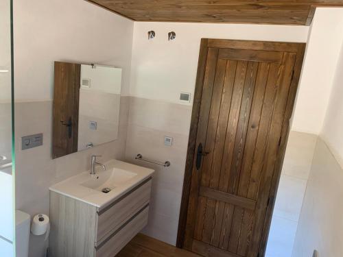 baño con lavabo y puerta de madera en Casa Rural Las Nueces, en Pozo Alcón