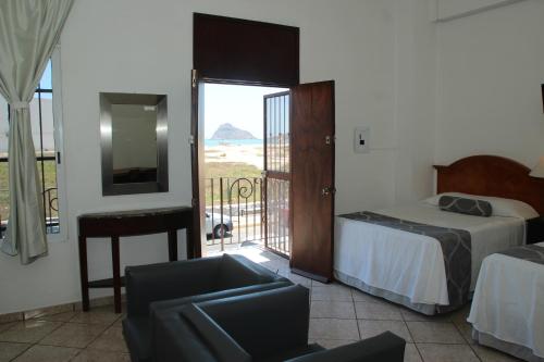 a bedroom with a bed and a view of the ocean at Hotel Posada Doña Rubino in Mazatlán