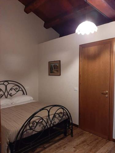 a bedroom with a bed and a wooden door at Il pozzo dei desideri in Castelnuovo