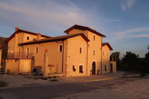 ein großes gelbes Gebäude mit vielen Fenstern in der Unterkunft Il pozzo dei desideri in Castelnuovo