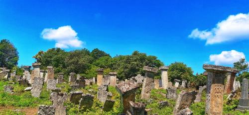 a row of stone crosses on a hill with a blue sky at Vila Milenovic Rajacke Pivnice in Rajac
