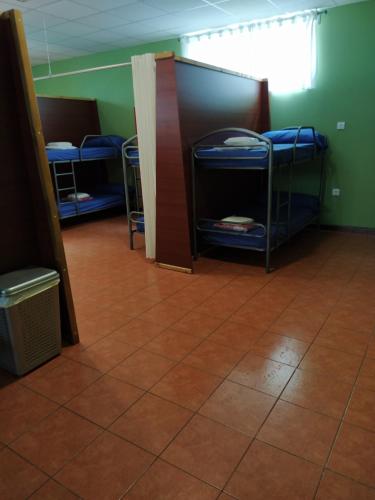 Zimmer mit 3 Etagenbetten und Fliesenboden in der Unterkunft Albergue O Bordón in Cee