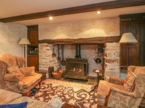 a living room with a fireplace and a stone wall at The Pend in Newton Stewart