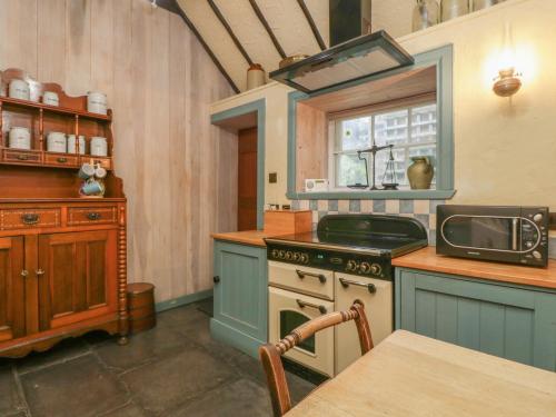 a kitchen with a stove and a window in it at The Precinct House in Newton Stewart