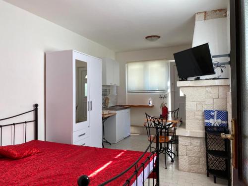 a bedroom with a bed and a kitchen with a fireplace at Anči in Pula