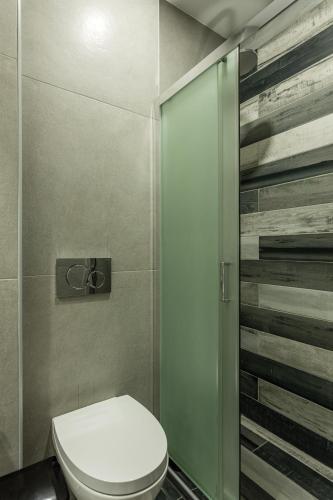 a bathroom with a toilet and a glass shower at Lefkis apartments & studios in Stoupa
