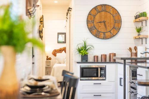 a kitchen with a clock on the wall at The Woods- Container Tiny House 12 min to Magnolia/Baylor/Downtown in Bellmead
