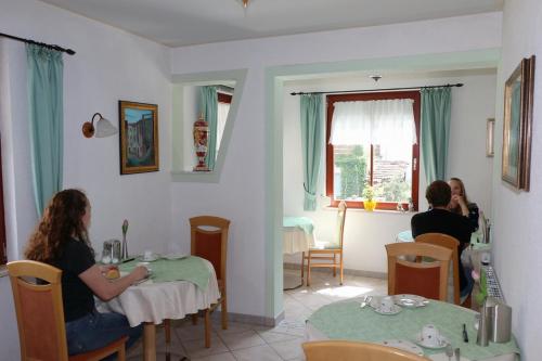 dos personas sentadas en mesas en un restaurante en Hotel Venezia, en Tübingen