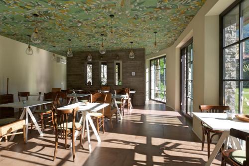 un ristorante con tavoli e sedie e un soffitto fiorito di Hotel Elvezia a Cannobio
