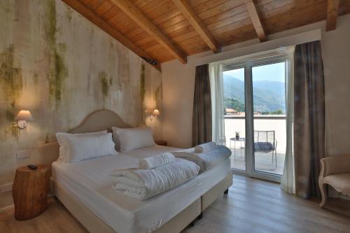 una camera da letto con un grande letto con una grande finestra di Hotel Elvezia a Cannobio
